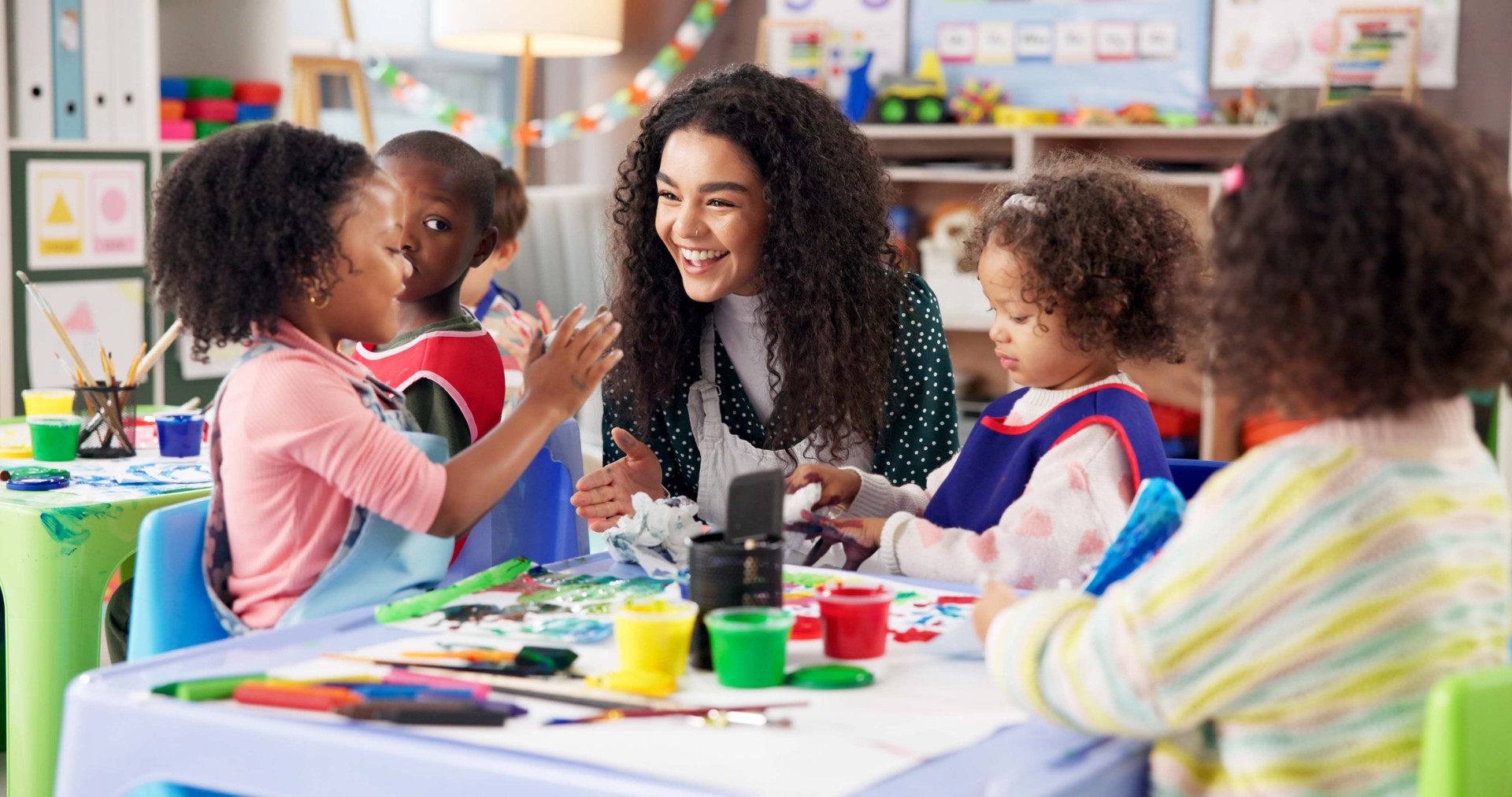 Education, children or painting with teacher in class for art, creative talent or motor skill development in preschool. Learning, students drawing or teaching happy kids for lesson or help with color Education, children or painting with teacher in class for art, creative talent or motor skill development in preschool. Learning, students drawing or teaching happy kids for lesson or help with color